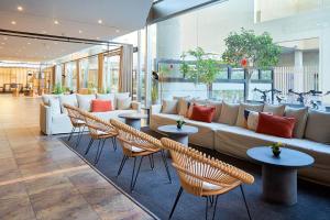 a lobby with a couch and chairs and tables at Eurostars Málaga in Málaga