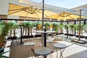 a patio with tables and chairs and umbrellas at Eurostars Málaga in Málaga