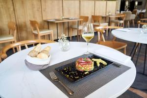 a table with a plate of food and a glass of wine at Eurostars Málaga in Málaga
