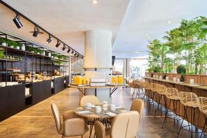 a restaurant with tables and chairs and a bar at Eurostars Málaga in Málaga