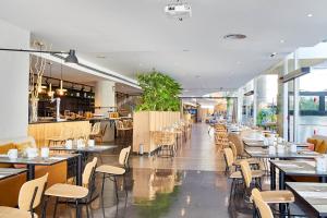 a dining room with tables and chairs in a restaurant at Eurostars Málaga in Málaga