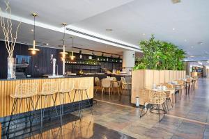 a restaurant with a bar and tables and chairs at Eurostars Málaga in Málaga