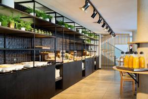 a restaurant with a counter with food on display at Eurostars Málaga in Málaga