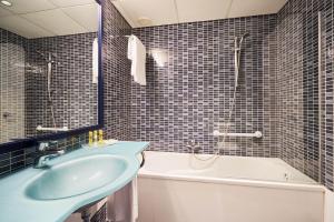 a bathroom with a tub and a sink and a bath tub at Eurostars Málaga in Málaga