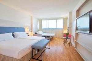 a hotel room with two beds and a window at Eurostars Málaga in Málaga