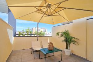 a patio with a table and a large umbrella at Eurostars Málaga in Málaga