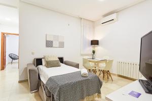 Zimmer mit einem Bett, einem Tisch und einem TV in der Unterkunft LEEWAYS APARTMENT XIX in GRAN VÍA in Madrid