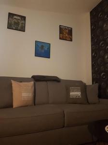 a brown couch in a living room with pictures on the wall at Le Rock Studio in Honfleur