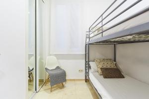 ein Schlafzimmer mit einem Etagenbett und einem Stuhl in der Unterkunft LEEWAYS APARTMENT XIX in GRAN VÍA in Madrid