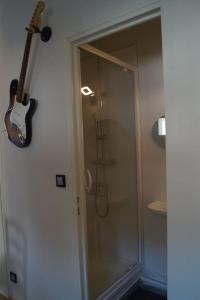 a guitar hanging on a wall next to a shower at Le Rock Studio in Honfleur