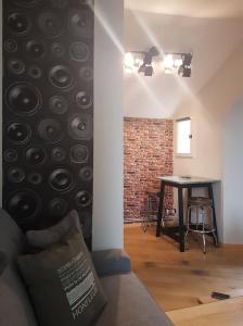 a living room with a table and a brick wall at Le Rock Studio in Honfleur