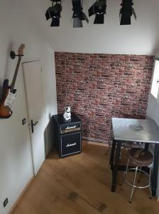 a room with a table and a brick wall at Le Rock Studio in Honfleur