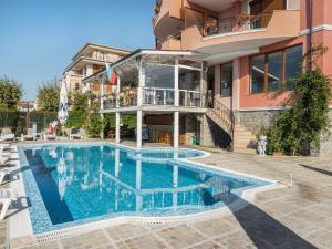 a swimming pool in front of a house at Hotel Fantasy Beach in Sveti Vlas