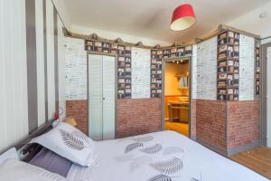 Un dormitorio con una pared de ladrillo y una cama. en L'Escale Marine - Couette et Café, en La Rochelle