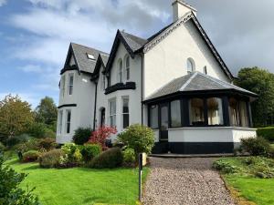 una casa blanca con techo negro en Ashburn House, en Fort William