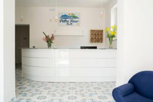 a waiting room with a counter and a blue chair at Villa Pietra Rossa in Diamante