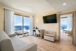 a hotel room with a bed and a desk and a television at Barceló Santiago - Adults Only in Puerto de Santiago