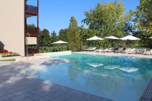 a swimming pool with chairs and umbrellas at Residenza Sante in Lazise