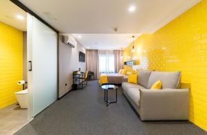 uma sala de estar com um sofá e uma parede amarela em Nest Style Valencia em Valência