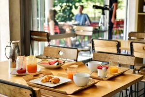 una mesa de madera con alimentos para el desayuno y bebidas. en Boutique Hotel Artemisia en Bastelica