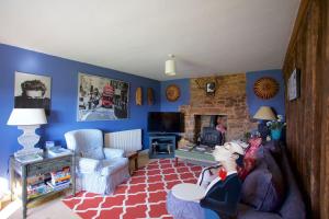 a living room with a doll sitting on a couch at Beautiful Devon Farmhouse in Exeter