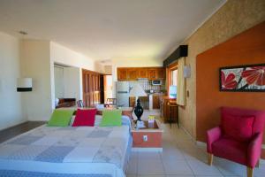 ein Schlafzimmer mit einem Bett und ein Wohnzimmer in der Unterkunft Villas del Sol en Los Tules in Puerto Vallarta