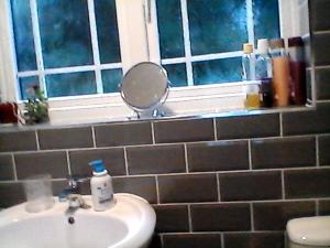 a bathroom with a sink and a mirror on a window at the brier house in Swadlincote