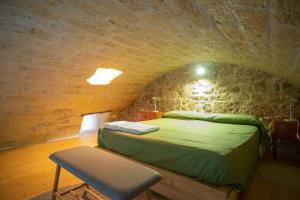 ein Schlafzimmer mit einem grünen Bett in einer Steinmauer in der Unterkunft Casa petra in Bari