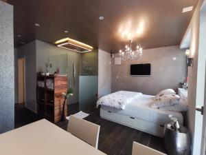 1 dormitorio con cama y lámpara de araña en Private Spa am Rennweg, en Amriswil