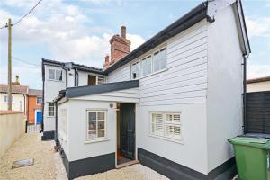 a white house with a black door at Best located and beautifully renovated cottage in Diss