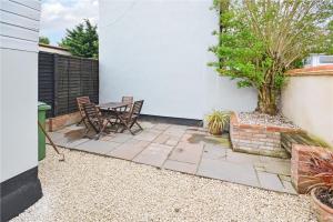 a patio with chairs and a table and a tree at Best located and beautifully renovated cottage in Diss