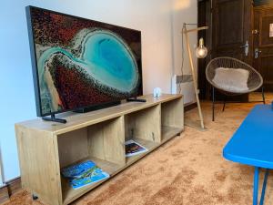 a living room with a flat screen tv on a wooden entertainment center at Arc 1950 Manoir Savoie Skis aux pieds in Bourg-Saint-Maurice