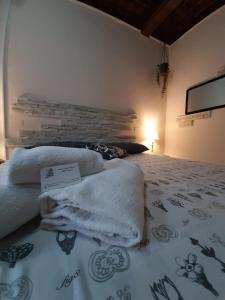 una camera da letto con un letto e asciugamani di Smile Tower House a Pisa