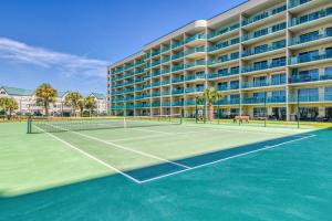 a tennis court in front of a large building at Plantation Dunes II in Gulf Shores