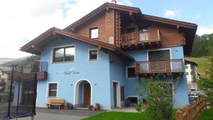 una casa azul con techo de madera en Chalet Teresa, en Livigno