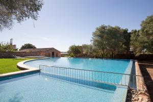 a large swimming pool with a fence around it at Hotel Son Cosmet in Campos