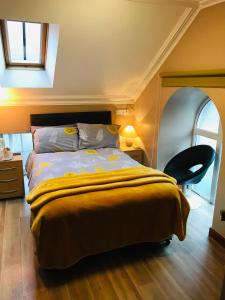 a bedroom with a bed with a yellow blanket at Pisgah Guesthouse Snowdonia in Blaenau-Ffestiniog