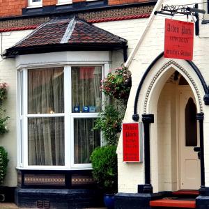 a house with a window and a sign in front of it at Arden Park Ensuite Rooms in Stratford-upon-Avon