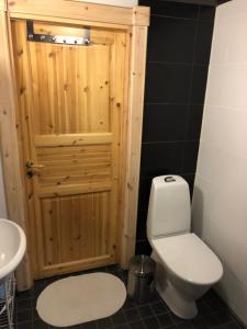 a bathroom with a toilet and a wooden door at Kenttäniemi Cottages in Sonka