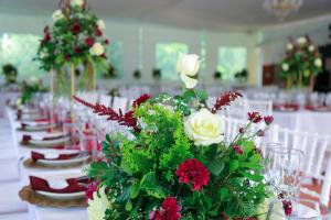 una mesa larga con sillas blancas y un ramo de flores en Hotel Mi Ranchito, en Xicotepec de Juárez