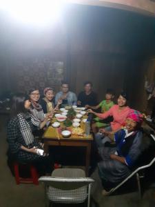 a group of people sitting around a table at Mu Cang Chai Hostel in Mù Cang Chải