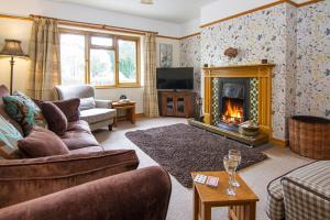 a living room with a couch and a fireplace at Bridge End Cottage in Coniston