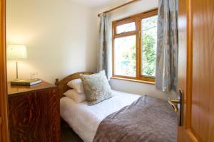 a small bedroom with a bed and a window at Bridge End Cottage in Coniston