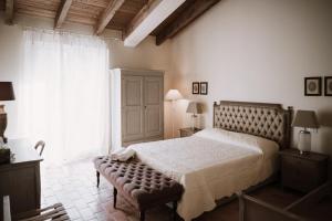 a bedroom with a large bed and a large window at Parco di Montebello in Quattro Castella