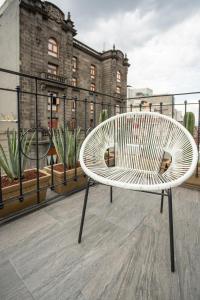 a white bench sitting on top of a balcony at Hotel Principal in Mexico City