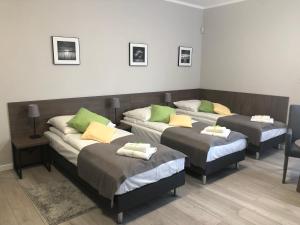 Habitación con 3 camas con almohadas verdes. en Villa Rosa, en Poznan