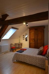 ein Schlafzimmer mit einem Bett und einem Dachfenster in der Unterkunft Les chambres de Marie'O in Brazey-en-Plaine
