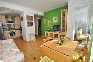 a living room with a table and a living room with green walls at 1095 Aquamarina in Roses