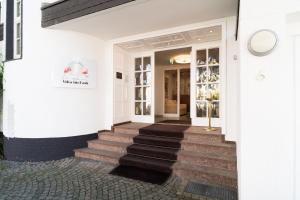 un bâtiment blanc avec des escaliers en face d'un magasin dans l'établissement Hotel Villa im Park, à Düsseldorf