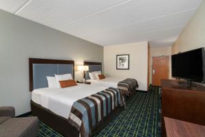 a hotel room with two beds and a flat screen tv at Wingate by Wyndham Fletcher at Asheville Airport in Fletcher